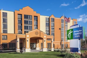 A Holiday Inn Express & Suites building with a prominent entrance and a flag. - Holiday Inn Express Hotel & Suites South Portland by IHG (South Portland)