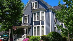 A two-story house with a porch, a sign indicating it is a bed and breakfast, and a vacant sign. - Brewster House Bed & Breakfast (Freeport)
