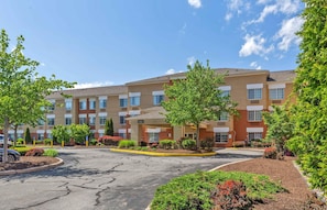 A multi-story hotel with a central lobby, outdoor parking, and landscaped areas. - Extended Stay America Suites Boston Burlington (Burlington)
