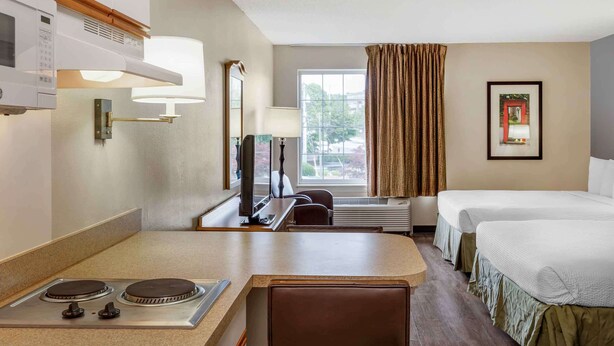 A hotel room with a kitchenette, a bed, a desk, and a window with curtains. - Extended Stay America Suites Boston Marlborough (Marlborough)
