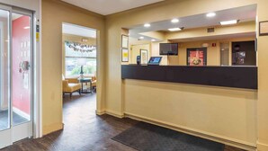 A reception area with a counter, a television, and a door leading to another room. - Extended Stay America Suites Boston Marlborough (Marlborough)