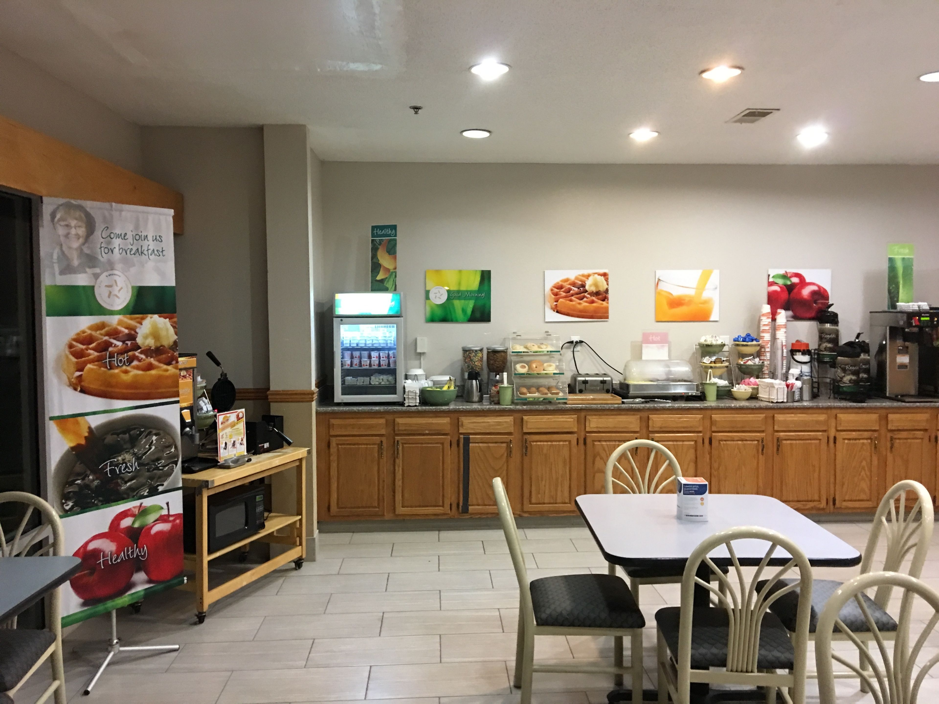 Un comedor con mostrador, refrigerador y zona de estar con sillas y mesa.