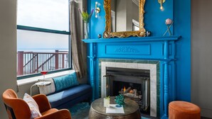 A room with a blue fireplace, a sofa, and two armchairs. - Landmark Inn (Marquette)