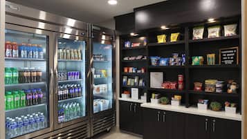 Un espace de vente proposant diverses boissons et collations, notamment de l’eau, des sodas et des chips.