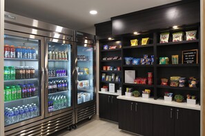 A vending area with various beverages and snacks, including water, sodas, and chips.