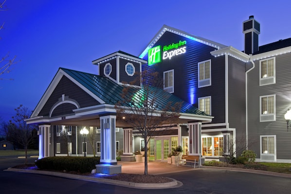 A Holiday Inn Express hotel with a prominent sign, a covered entrance, and a well-lit facade.
