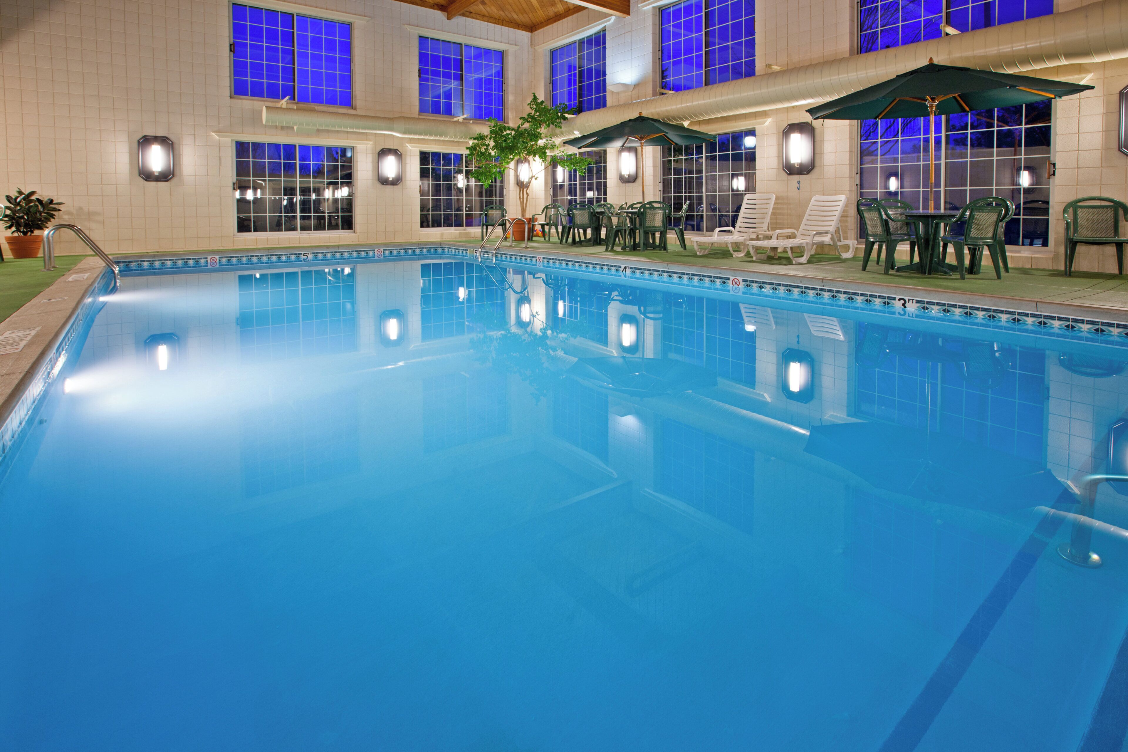 Una piscina techada, sillones reclinables de piscina