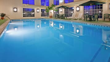 Una piscina techada, sillones reclinables de piscina