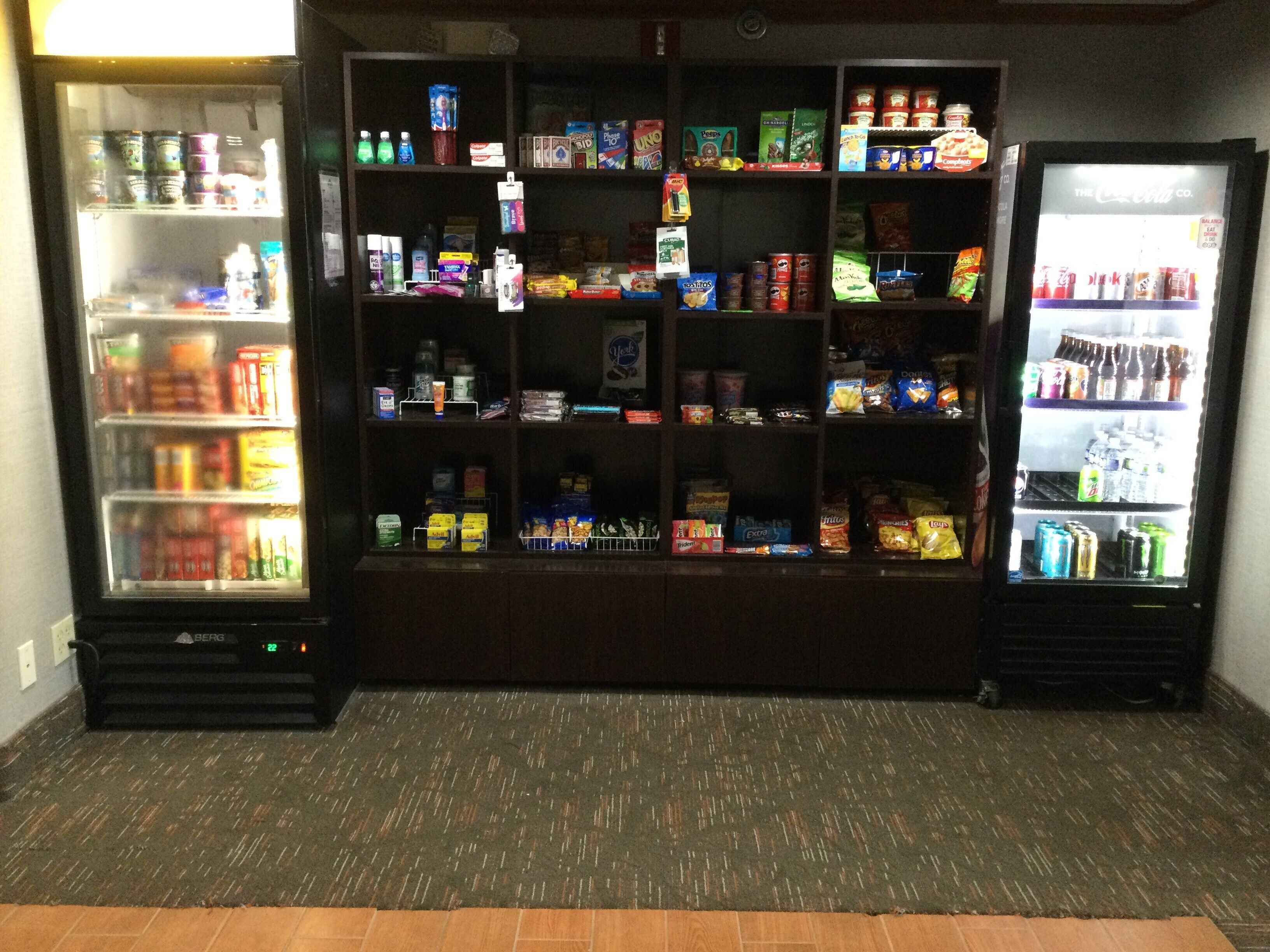 A vending machine area with multiple shelves stocked with snacks, drinks, and other items.