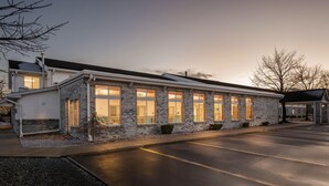 A two-story building with large windows and a garage. - Days Inn by Wyndham Imlay City (Imlay City)