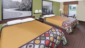 A hotel room with two beds, a desk, a chair, a lamp, and a window with a view of a bridge and trees.
