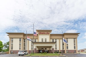 Un hotel Hampton Inn con fachada plana, entrada central y estacionamiento.