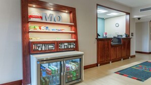 A hotel lobby with a minibar, a clock on the wall, and a reception desk. - Hampton Inn Jefferson City at Capital Mall (Jefferson City)
