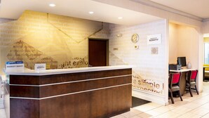 A reception desk with a wooden finish, a clock, and a sign for Marriott Bonvoy. - Fairfield Inn & Suites by Marriott St. Louis Chesterfield (Chesterfield)