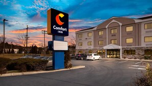 Un hotel Comfort Inn con un letrero grande, un estacionamiento y un edificio con varias ventanas.