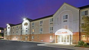Een hotel met een modern design, met een opvallende entree en een bordje met de tekst 'Sonesta Simply Suites'. Het gebouw heeft meerdere verdiepingen, een uniforme gevel en een plat dak.