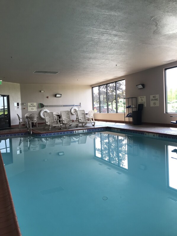 An indoor swimming pool with clear water, marked depth levels, and no diving signs.