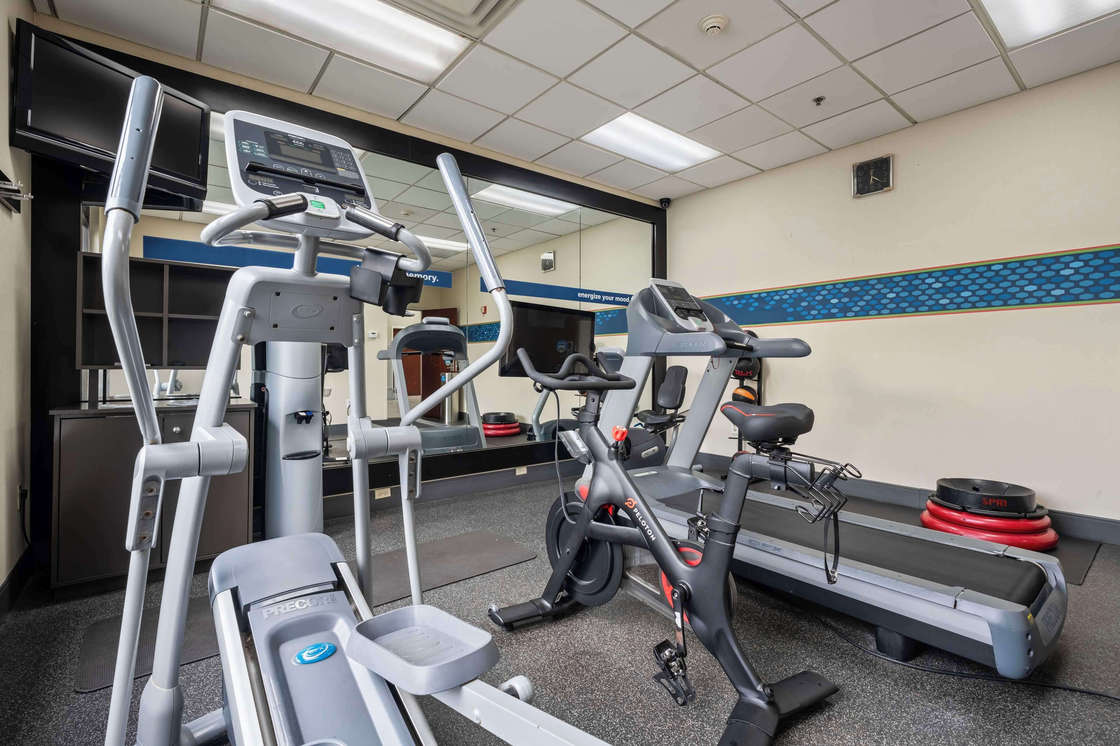 A gym with cardio machines, a treadmill, and a stationary bike.
