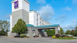 Hotel Sleep Inn by Wyndham con diseño moderno, entrada cubierta y jardines.