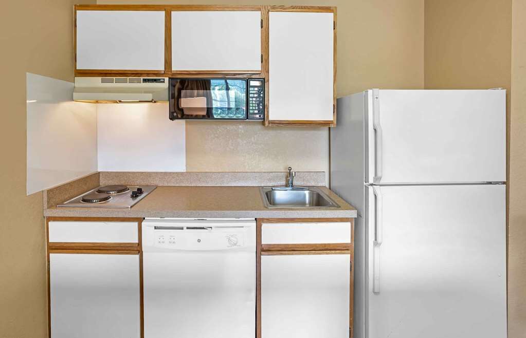 A compact kitchen with a microwave, stove, sink, dishwasher, and refrigerator.