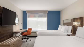A hotel room with two beds, a desk, a chair, a TV, and a large window.