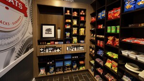 A snack display in a store with various packaged snacks and beverages. - Hampton Inn & Suites Raleigh Cary Lenovo Center (Raleigh)
