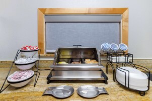 Montaje de bufé con diferentes alimentos y utensilios para servir.