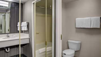 Un baño moderno con ducha acristalada, lavabo blanco y retrete.