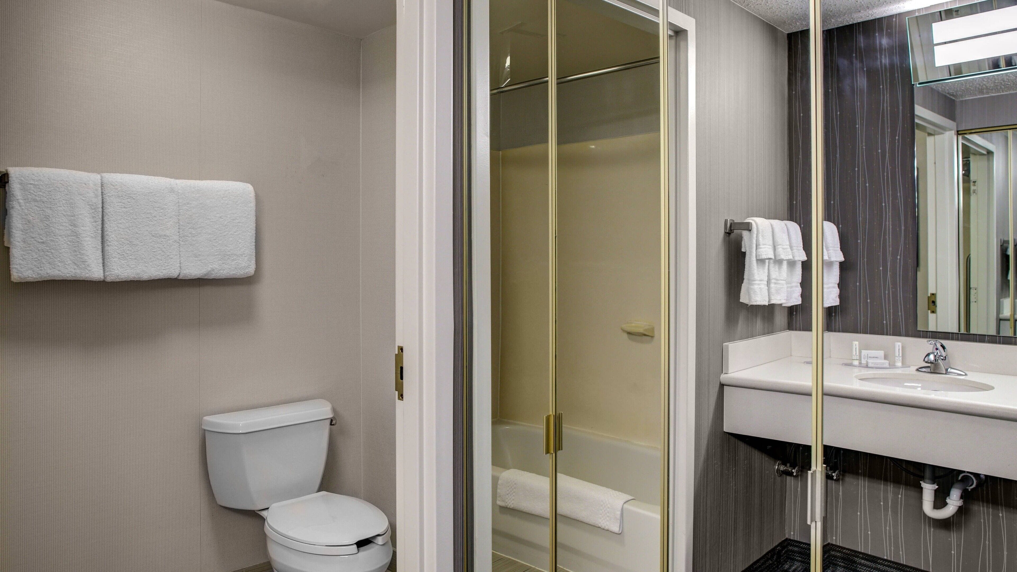 Et badeværelse med toilet, badekar og håndvask.