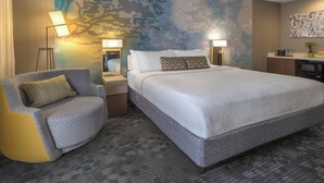 A modern hotel room with a large bed, a seating area with a chair, a desk, and a wall mural. - Courtyard by Marriott Cleveland Westlake (Westlake)