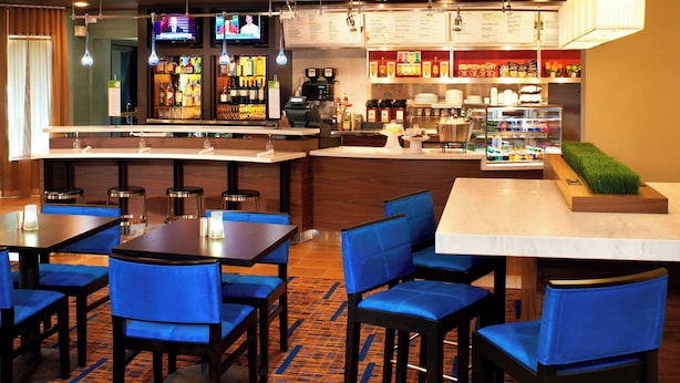 A hotel bar area with multiple seating options, a bar counter, and a variety of food and beverage displays. - Courtyard by Marriott Cleveland Westlake (Westlake)