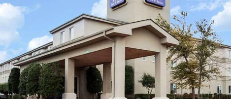 A Sleep Inn hotel with a covered entrance and a signboard.
