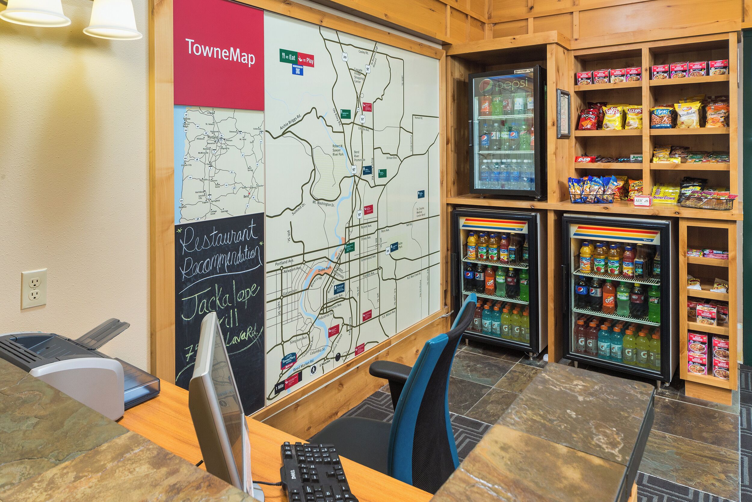 A map on the wall, a computer, a printer, and snack shelves.
