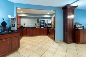 A kitchen with a waffle maker, coffee machine, and a fruit display. - Hawthorn Suites by Wyndham Allentown-Fogelsville (Fogelsville)