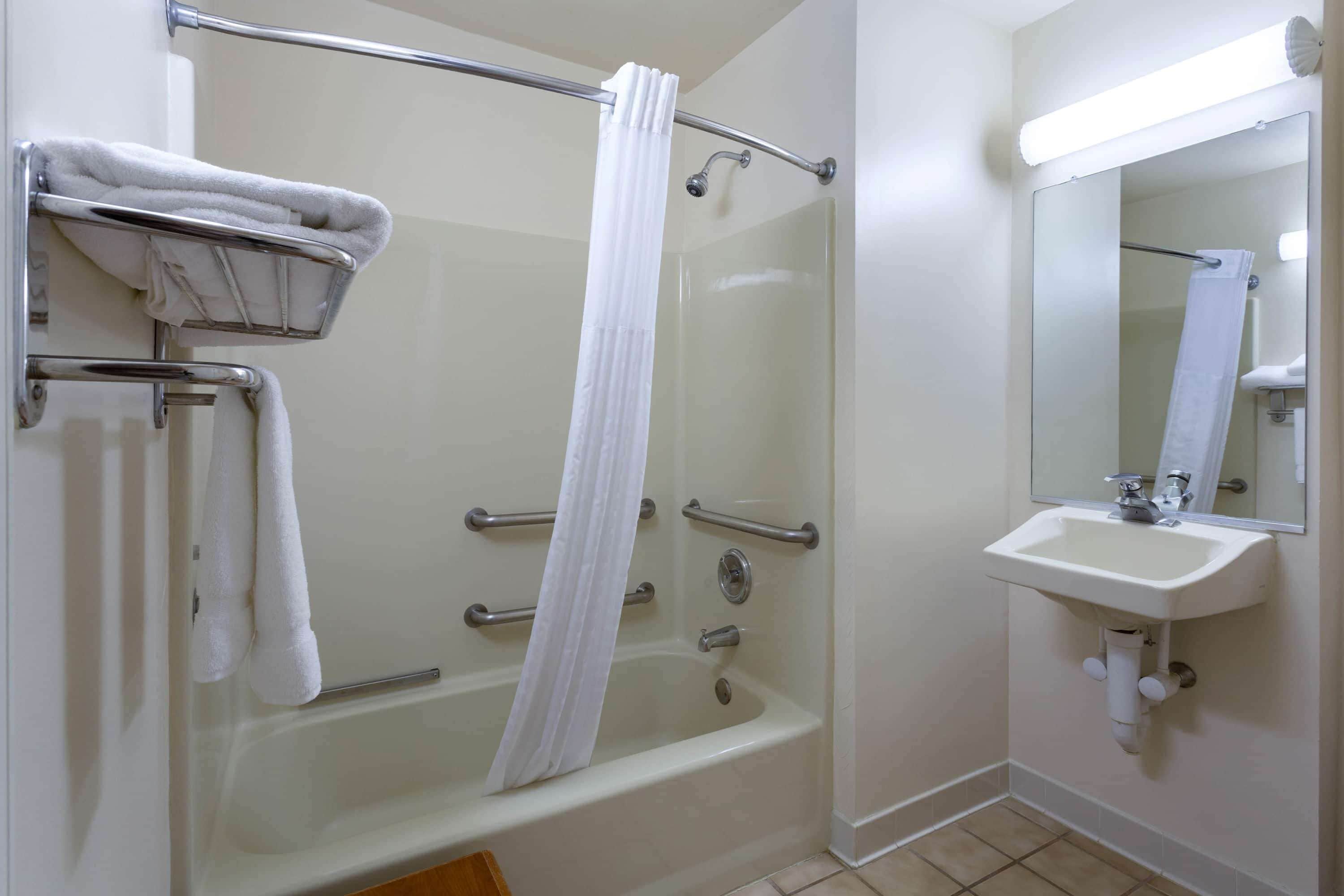 Une salle de bain avec une baignoire, une douche et un lavabo.