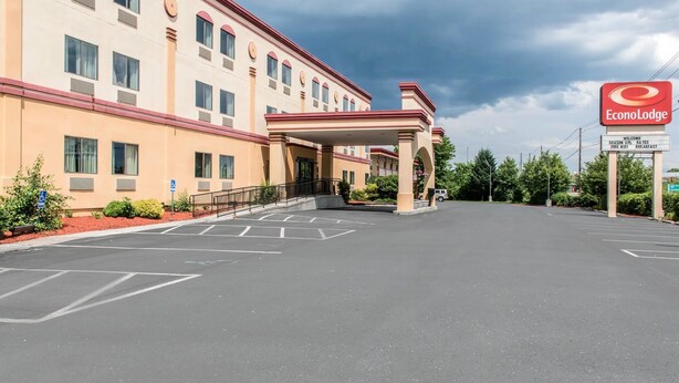 Un hotel con entrada techada, estacionamiento y el letrero de EconoLodge.