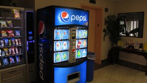 Máquina expendedora con logotipo de Pepsi y diversas opciones de bebidas.