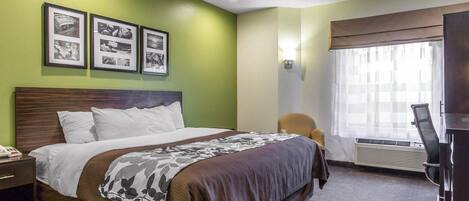 Une chambre d’hôtel comprenant un lit, une chaise, un bureau avec un téléphone et un téléviseur.