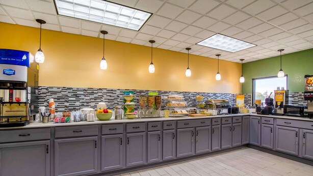 A breakfast bar with a variety of food options, a coffee machine, and a seating area with a view.