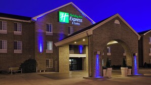 A Holiday Inn Express & Suites building with a brick facade, illuminated signage, and a covered entrance area. - Holiday Inn Express & Suites Sioux Falls At Empire Mall by IHG (Sioux Falls)
