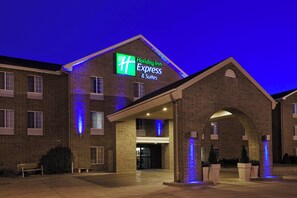 A Holiday Inn Express & Suites building with a brick facade, illuminated signage, and a covered entrance area. - Holiday Inn Express & Suites Sioux Falls At Empire Mall by IHG (Sioux Falls)