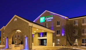 Un hotel Holiday Inn Express & Suites con fachada de ladrillo y señalización iluminada.