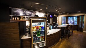 A bar area with a refrigerated drink dispenser, a menu board, and a seating area with a view of the outdoors. - Courtyard by Marriott Memphis East/Bill Morris Parkway (Memphis)