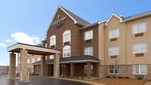 A Country Inn & Suites building with a brown facade, multiple windows, and a covered entrance area. - Country Inn & Suites by Radisson, Jackson, TN (Jackson)