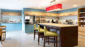 A modern kitchen with a central island, bar stools, and a red pendant light. - Country Inn & Suites by Radisson, Jackson, TN (Jackson)