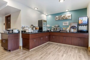 Una cocina moderna con armarios de madera, una estación de café y un dispensador de agua.