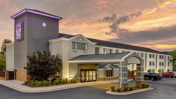 Un hôtel Sleep Inn au design moderne, doté d’une entrée imposante et d’un parking.