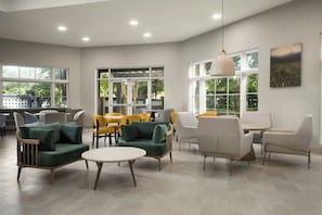 A modern lounge area with seating arrangements, large windows, and a ceiling light fixture. - Fairfield Inn & Suites by Marriott Austin Southwest (Austin)