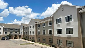A multi-story hotel with a modern design, featuring a parking lot and a covered entrance. - Extended Stay America Suites Houston Med Ctr Greenway Plaza (Houston)