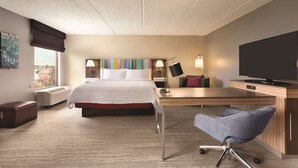 A hotel room with a bed, desk, chair, TV, and artwork on the wall. - Hampton Inn Houston-Brookhollow (Houston)